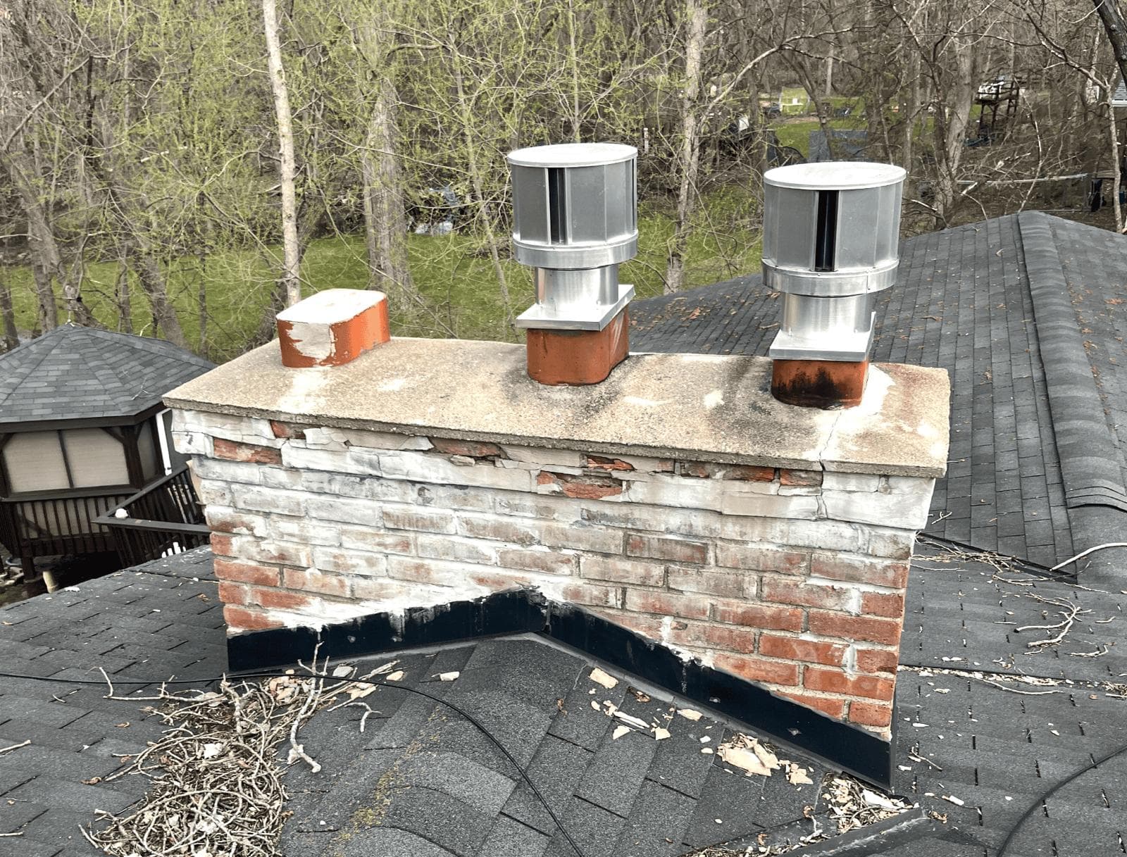 Kansas City chimney with spalled brick faces, eroded mortar joints and white efflorescence below a cracked concrete crown